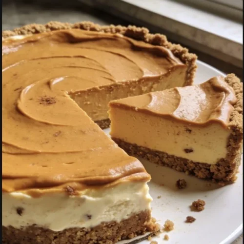 Delicious slice of pumpkin cheesecake topped with whipped cream and cinnamon