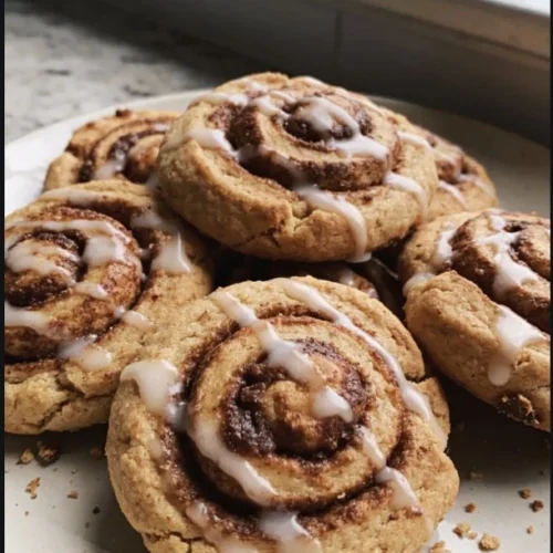 Freshly baked Cinnamon Roll Cookies topped with icing on a cooling rack