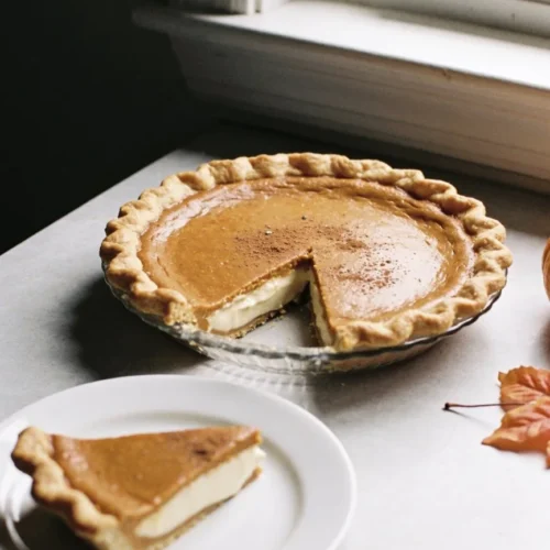 Classic Pumpkin Pie with whipped cream on a wooden table