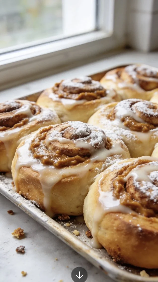 Freshly baked pumpkin butter cinnamon rolls with icing on top