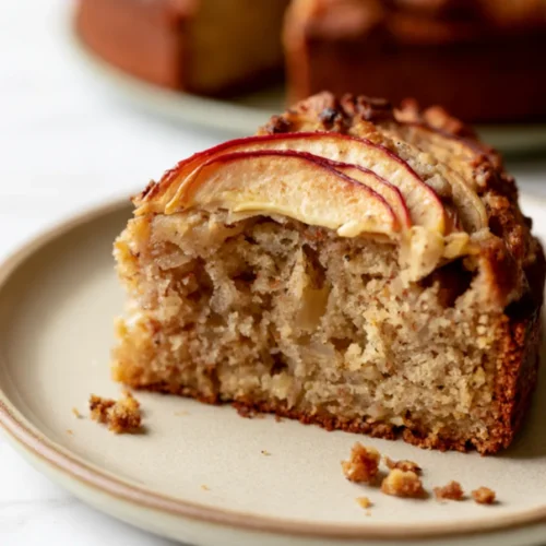 Slice of air fryer apple cake with a glazed spiral of apple slices on top